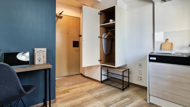 A compact kitchen with a built-in dishwasher, a small dining table, and a chair. - Modern Living Tokyo Komagome 508, a compact studio at excellent location (豊島区 駒込)