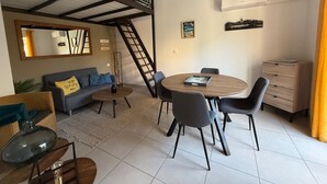 Ein modernes Wohnzimmer mit Schlafgalerie, Essbereich und Treppe.