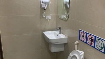 Een badkamer met toilet, wastafel en spiegel.