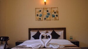 A hotel room with a bed, a nightstand, a chair, and wall art. - Pinewood Manor Kasauli (Solan)