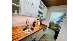 A kitchen with a wooden countertop, stainless steel sink, and white cabinets. - Le Bois Gentil 3* - lounge + sleeping area, pets welcome (La Clusaz)