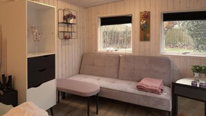 A cozy room with a sofa, a small table, and a window with a view of trees. - Beautiful home in Glesborg with WiFi (Glesborg)