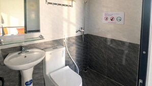 Un baño con inodoro, lavabo y ducha.