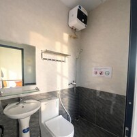 Un baño con inodoro, lavabo y ducha.