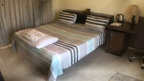Ein ordentlich eingerichtetes Schlafzimmer mit Bett, Nachttischen, Schreibtisch und Lampe.