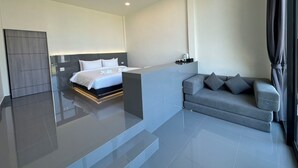 A modern hotel room with a large bed, a grey sofa, and a small table with a lamp. - Pearlix Koh Mook (Ko Mook)