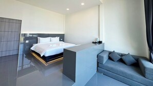 A modern hotel room with a large bed, a sofa, and a small table. - Pearlix Koh Mook (Ko Mook)