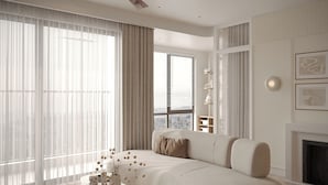 A modern living room with a large sectional sofa, a round coffee table, and a ceiling fan. - The Aura Patong (Patong)