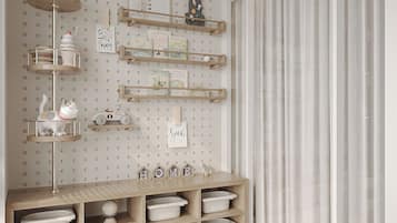 A room with a pegboard wall, shelves with books and decorative items, a wooden desk with storage bins, and a large window with curtains.