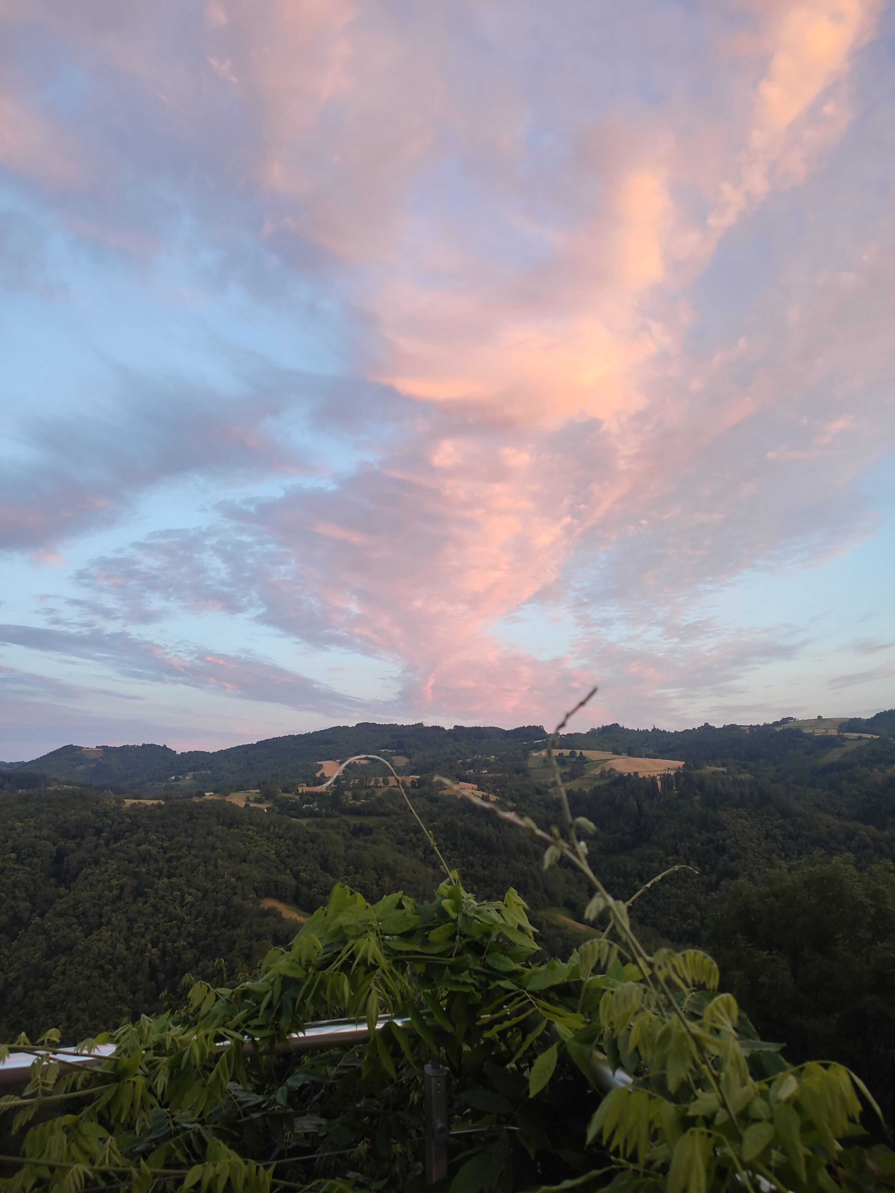 Un paisaje con vistas a colinas onduladas y un cielo nublado.