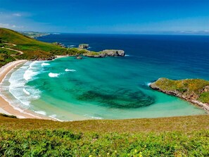 A coastal landscape with a beach, clear waters, and rocky outcrops. - IDEAL PARA DESCANSAR O HACER TURISMO CON LA FAMILIA Y AMIGOS. (Alles)
