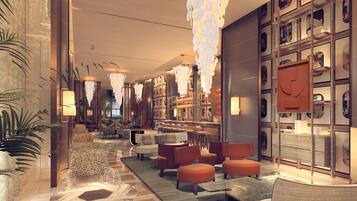 Un moderno vestíbulo de hotel con zona de bar, arreglos de asientos e iluminación decorativa.