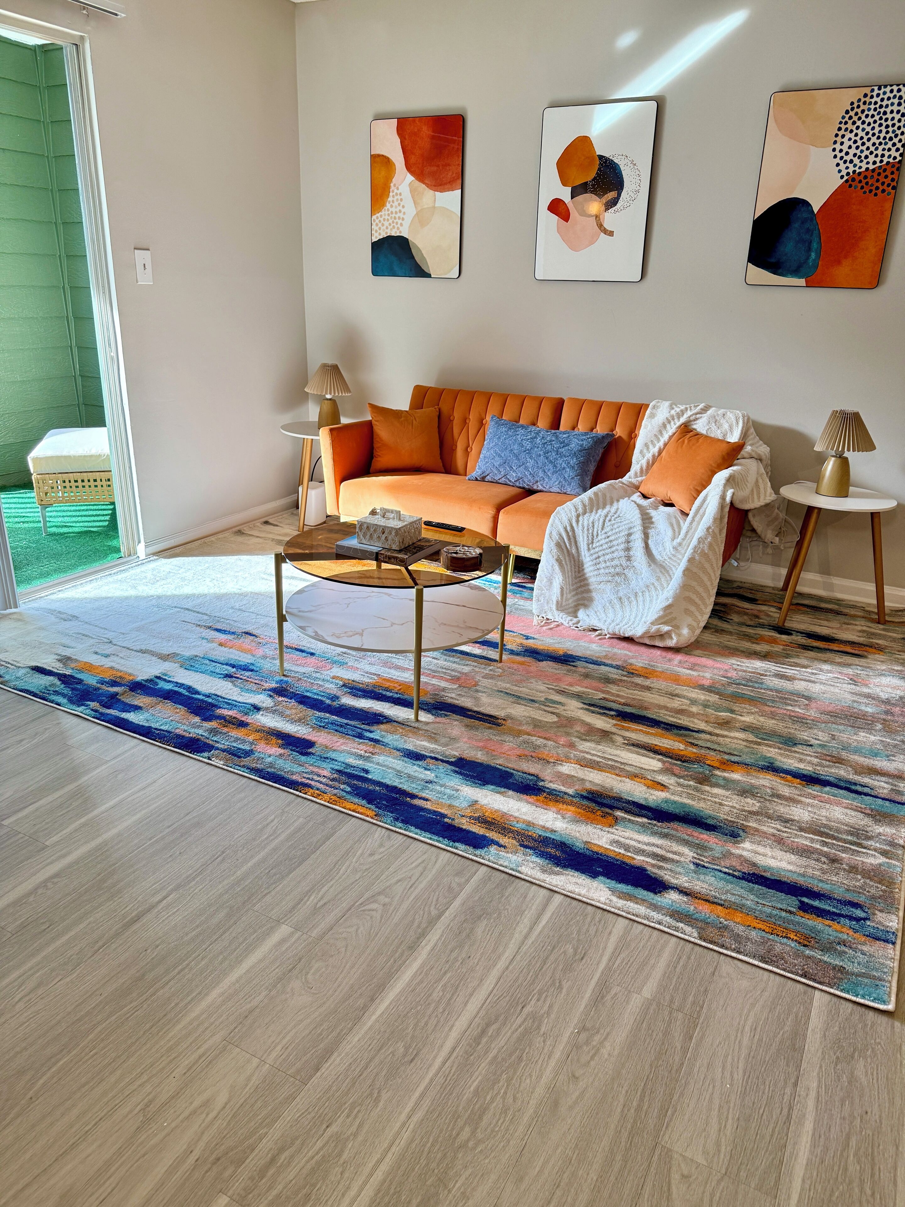 Un salon moderne avec un canapé, une table basse et des œuvres d’art accrochées au mur.