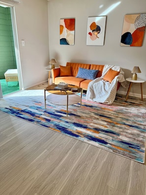 Ein modernes Wohnzimmer mit Sofa, Couchtisch und einem Kunstwerk an der Wand.