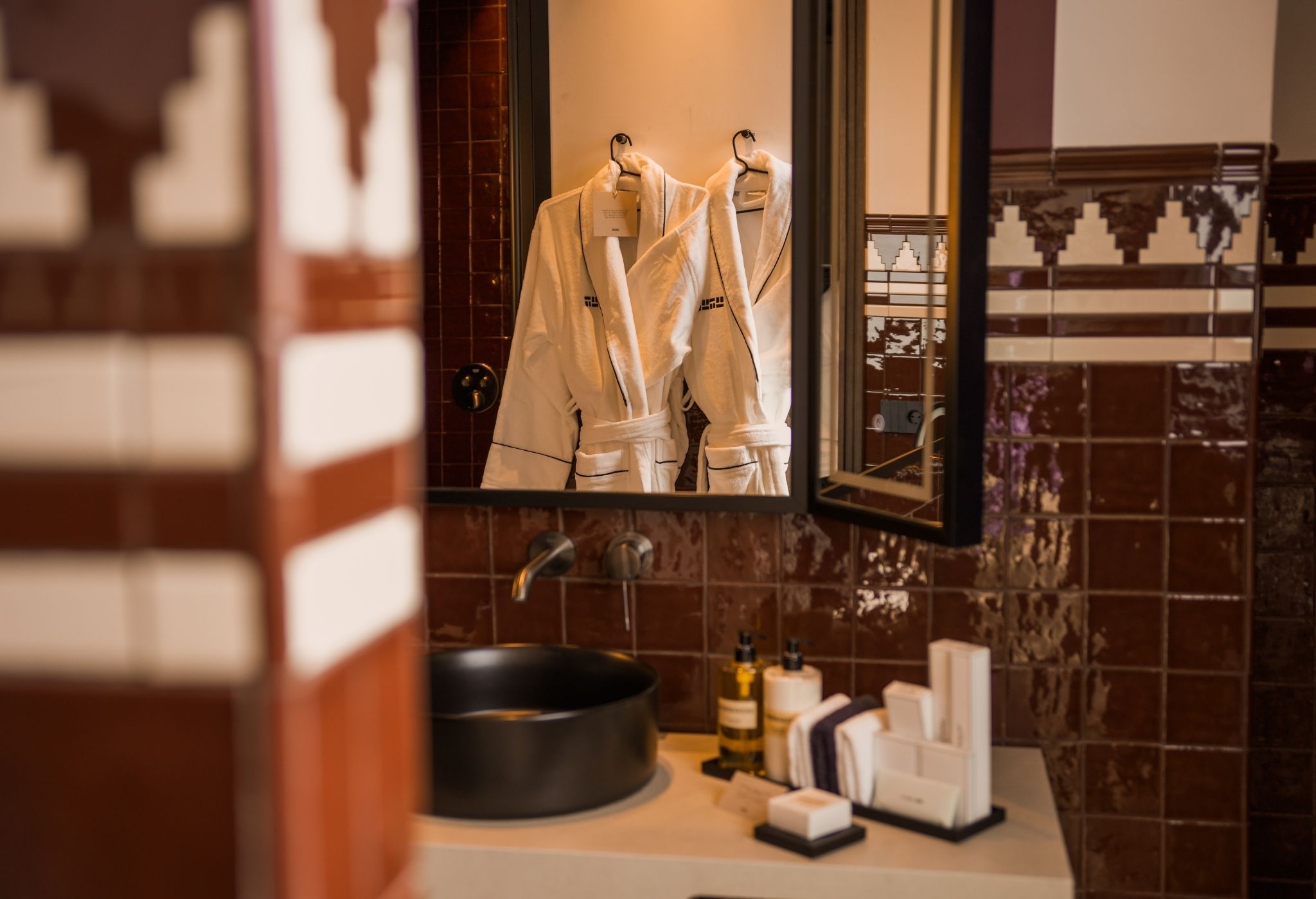 Un baño con lavamanos, espejo y artículos de aseo.