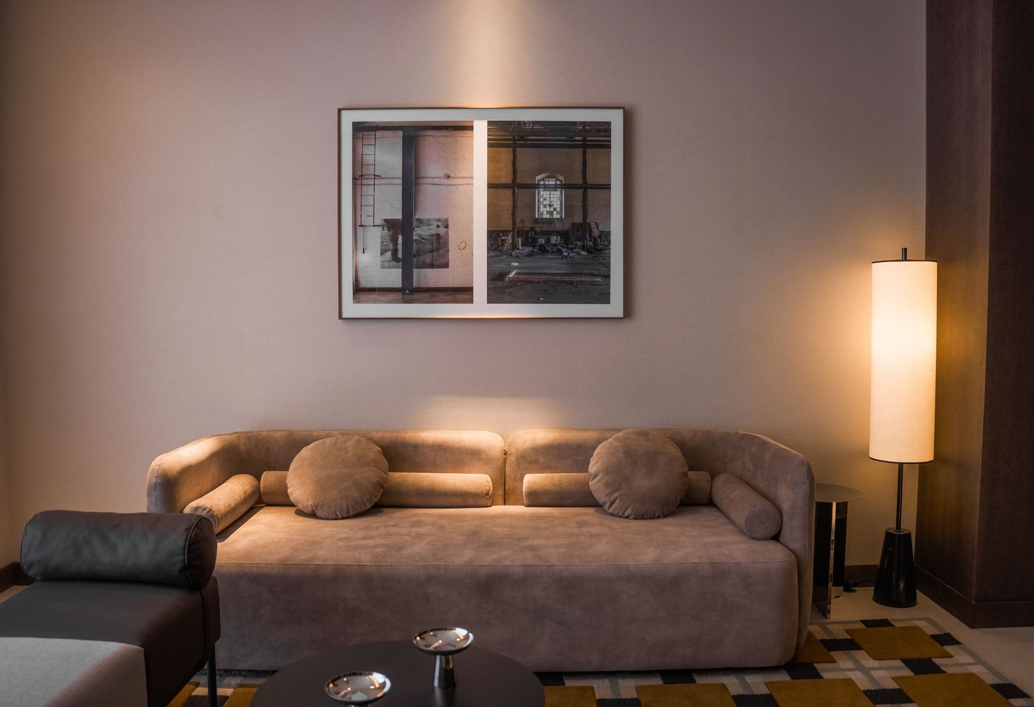Un salon avec un canapé, une table basse et un tableau encadré au mur.