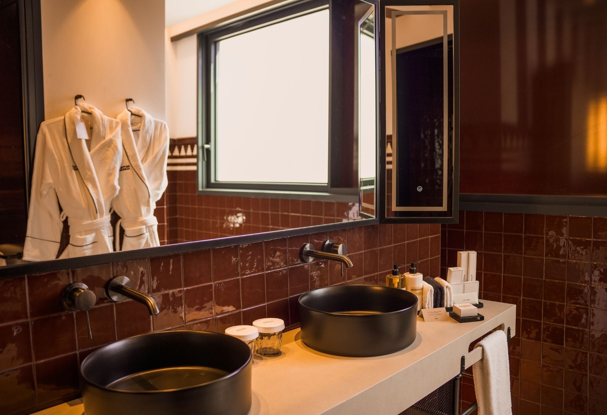 Un baño con lavamanos doble, espejo y ventana.