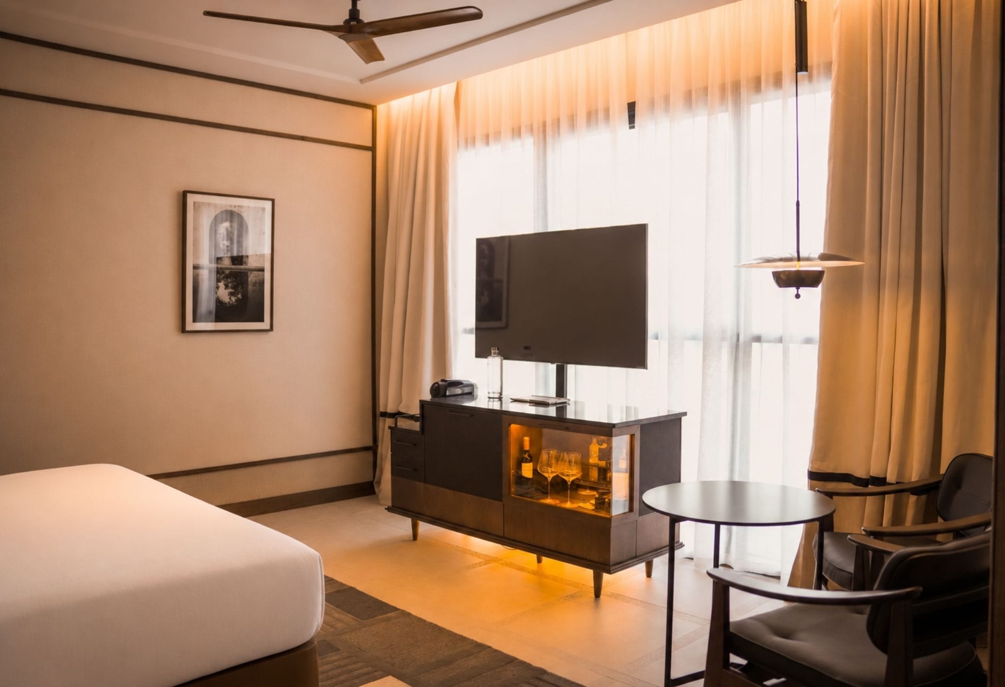 Une chambre d’hôtel équipée d’un lit, d’une télévision, d’un minibar, d’un bureau et d’une chaise.