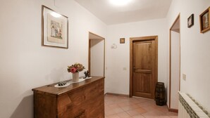 A hallway with a wooden dresser, a framed picture on the wall, a door, and a radiator. - Lovely home in Santa Fiora (Santa Fiora)