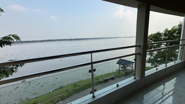 Une vue depuis un balcon donnant sur une étendue d’eau calme, avec une côte visible au loin.