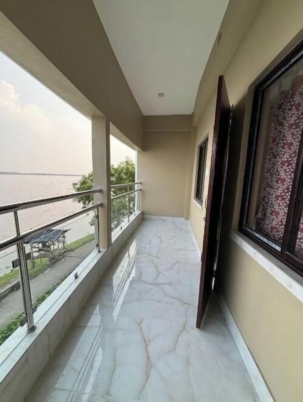 Ein Balkon mit Meerblick, Steinböden und einer Geländer.