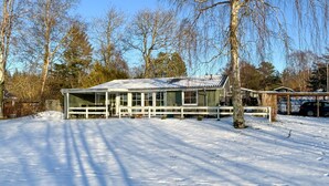 A modern house with a large glass window area, surrounded by snow-covered ground and trees. - 3 bedroom awesome home in Farsø (Farsø)