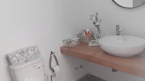 A modern bathroom with a toilet, sink, and mirror. - Serene Apartment Escape in Achada Fazenda, Cabo Verde (Ilha Santiago)