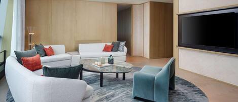 A modern living room with a sofa set, a coffee table, a TV, and a unique ceiling light fixture.