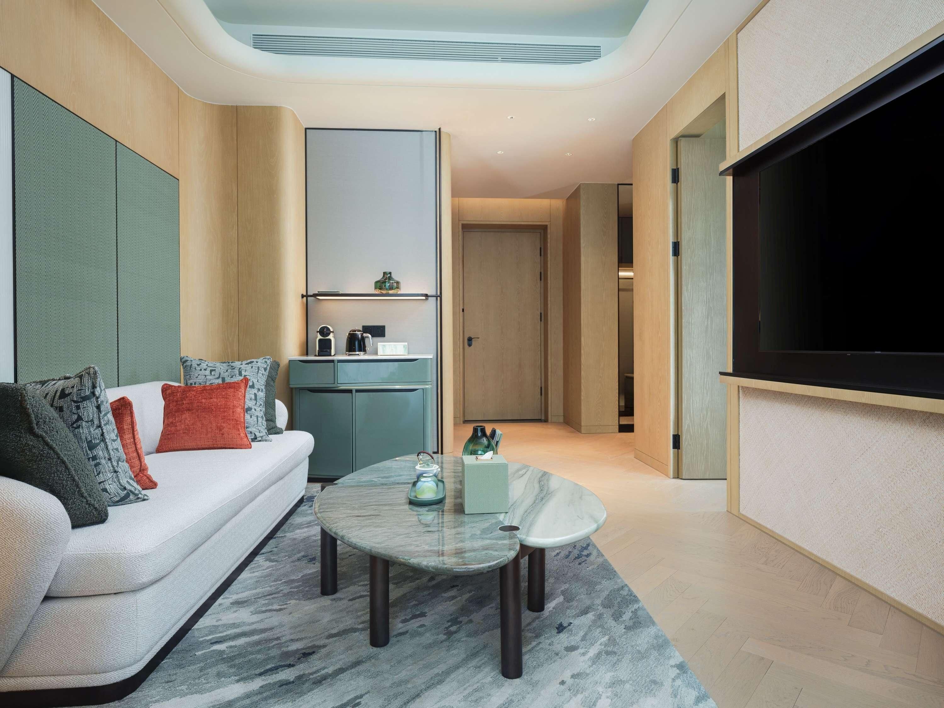 Un salon moderne avec un canapé, une table basse et un téléviseur à écran plat.