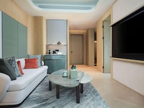 Una sala de estar moderna con un sofá, una mesa de centro y un televisor de pantalla plana.