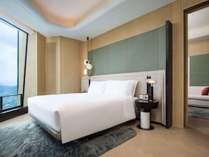 A modern hotel room with a large bed, a nightstand, a view of the outdoors, and a unique ceiling design.