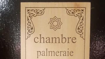 A sign with the text 'chambre palmeraie 106' surrounded by decorative borders.