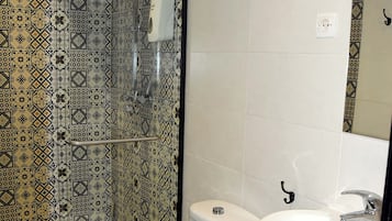 A bathroom with a toilet, sink, and shower.