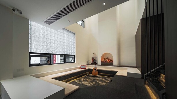 Une chambre moderne avec une grande fenêtre, une cheminée et une guitare.