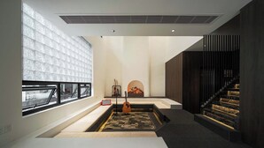 Un intérieur moderne avec une cheminée, une guitare et un escalier.