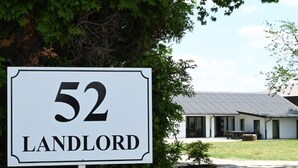 Un cartello con il numero 52 e la scritta 'LANDLORD', che indica una proprietà o un'attività.