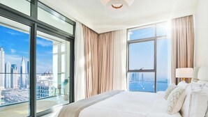 A hotel room with a large bed, a view of the cityscape, and a balcony with a glass door. - LUX ULTRA Luxury Palm Dubai Eye Suite (Dubai)