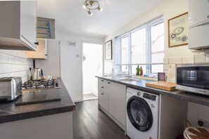 Eine moderne Küche mit integriertem Waschtrockner, einer Mikrowelle und einem Toaster.