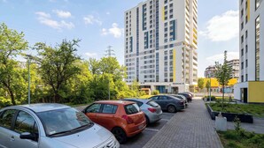 Een parkeerplaats met diverse auto's, omgeven door groen en moderne gebouwen.