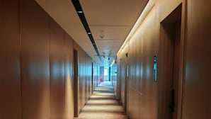 A long, narrow hallway with wooden walls and doors, leading to a bright end. - Hiatu Hotel   Huidong Huangbu Branch (Huizhou)