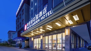 A hotel entrance with a large illuminated sign, a covered entrance area, and a modern architectural design. - Hiatu Hotel   Huidong Huangbu Branch (Huizhou)