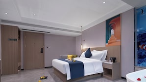 A modern hotel room with a large bed, a bedside table, a nightstand, a bathroom with a bathtub, and a large wall mural. - Hiatu Hotel   Huidong Huangbu Branch (Huizhou)