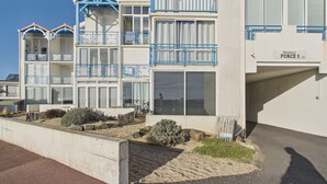 A multi-story building with balconies, a sign reading "Résidence FORCE 5", and a concrete planter with shrubs. - Sea view, beach 300 m away, apartment for 5 (Saint-Hilaire-de-Riez)