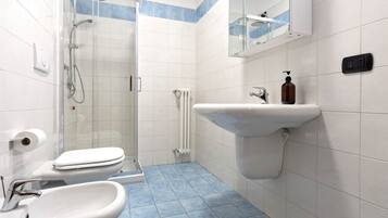 A bathroom with a toilet, sink, and shower.
