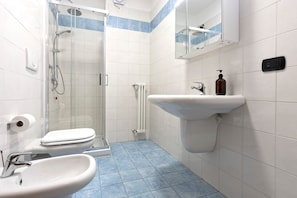 A bathroom with a toilet, sink, and shower.