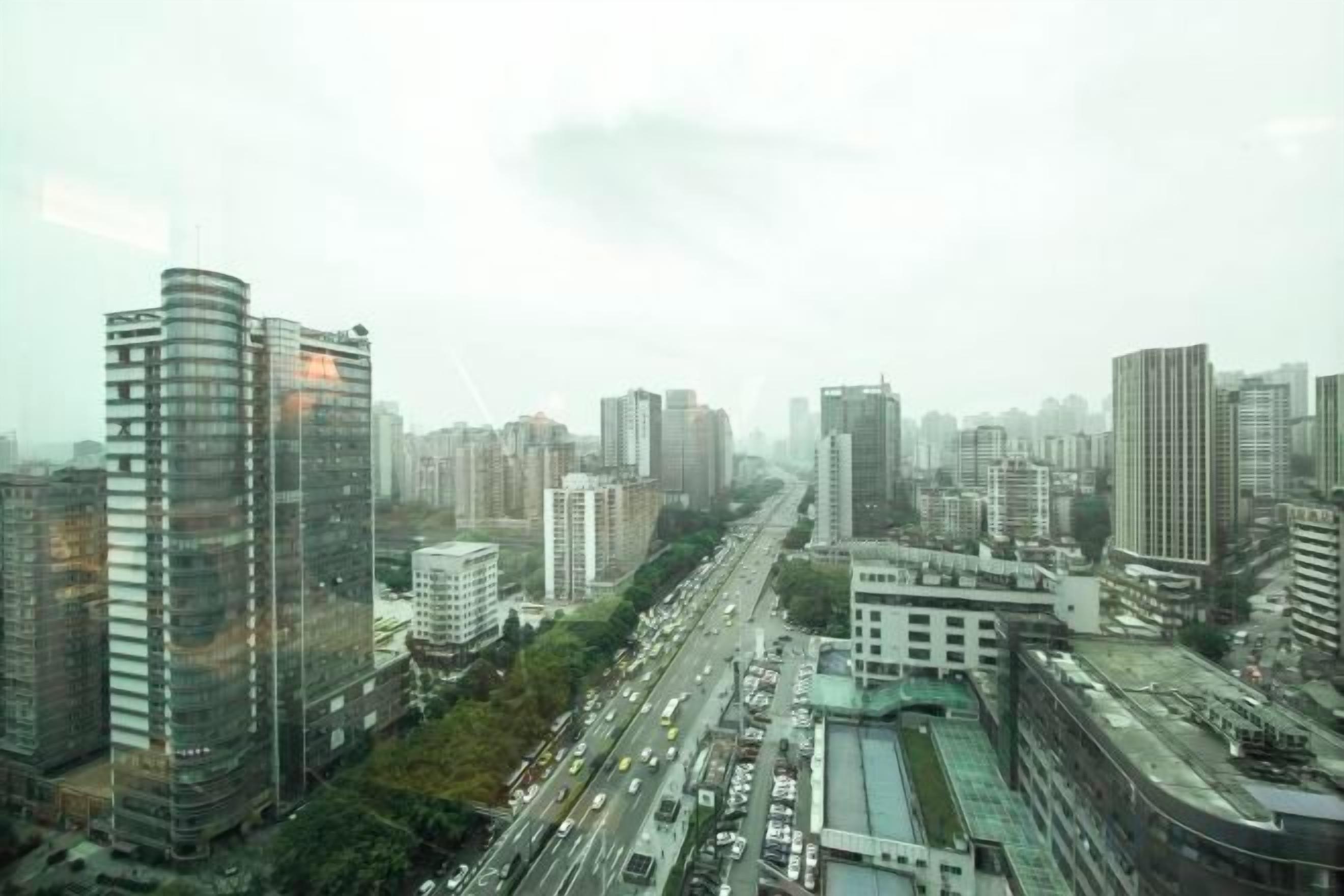 Un paisaje urbano con rascacielos, una calle concurrida y cielo despejado.