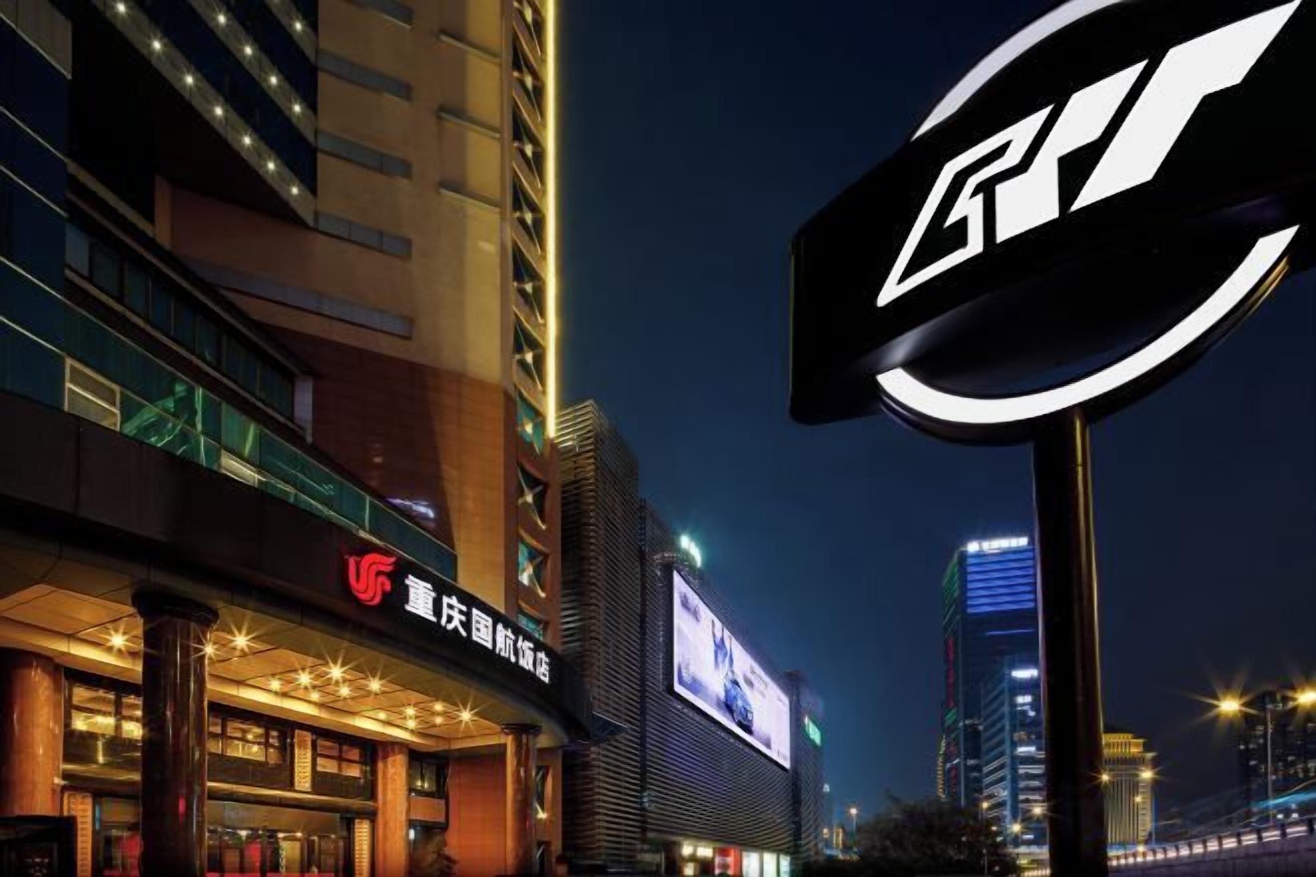 A hotel with a prominent sign, a large digital billboard, and a modern building facade.