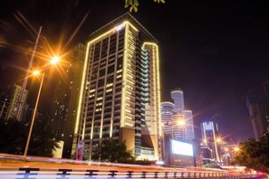 Un edificio de gran altura con diseño moderno, que destaca por su entrada principal y varios pisos.