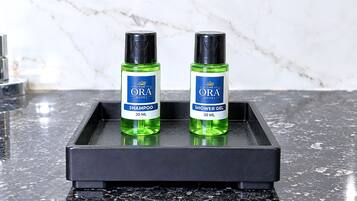 Two bottles of ORA Hotel shampoo and shower gel on a black tray.