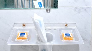Ein Waschtisch mit zwei Seifenspendern und einem Papierhandtuchhalter.